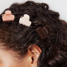 Woman with dark curly hair wearing Kitsch mini cloud claw clips