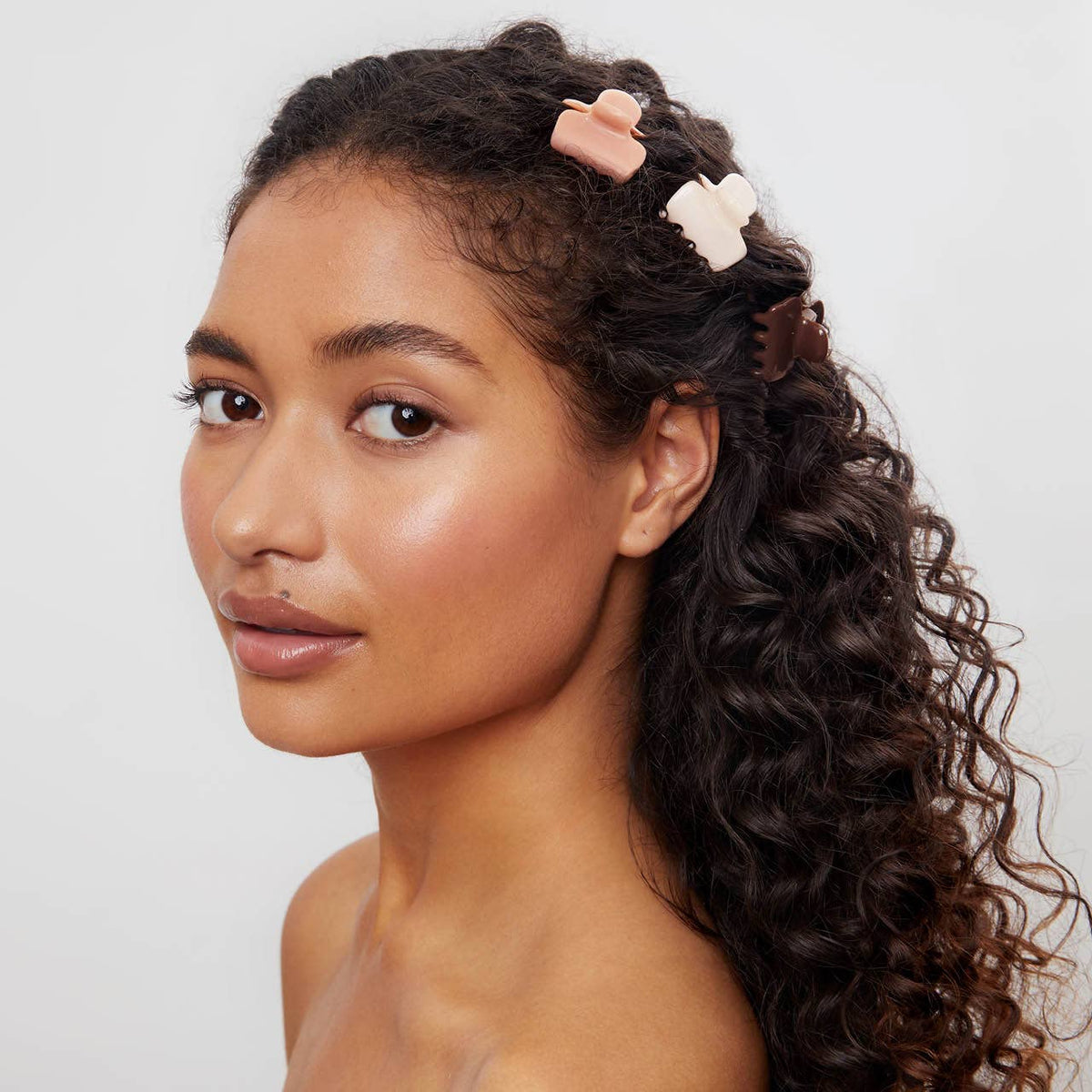 Woman with curly hair pinned back with Kitsch mini cloud claw clips
