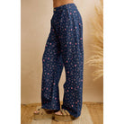 Side profile of relaxed navy floral print wide leg pants showing the curved leg shape