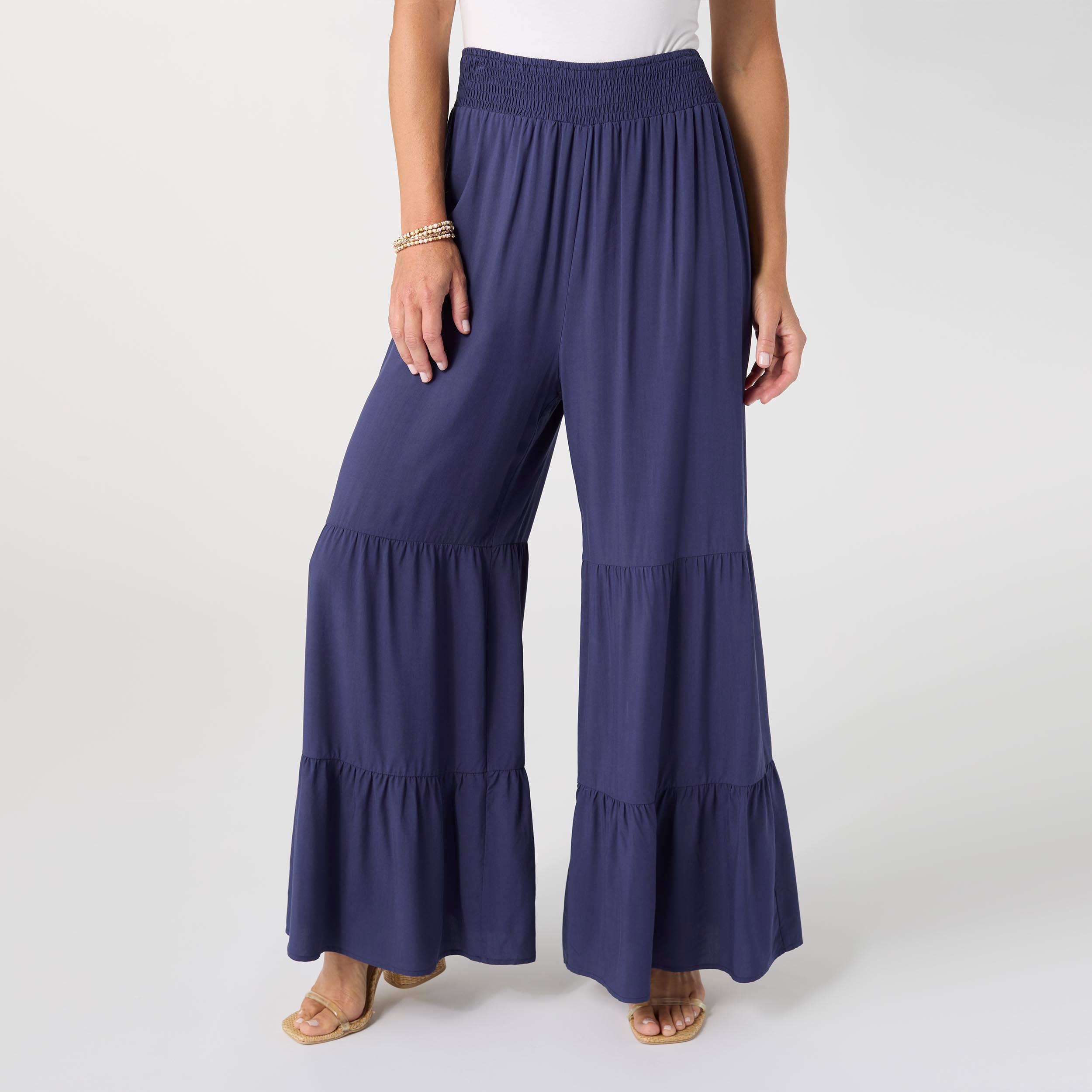 Navy blue tiered pants worn by a person on a white background