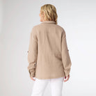 Woman wearing a beige jacket on a white background