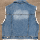 Blue denim vest with lace trim on a wooden surface