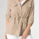 Woman wearing a beige jacket with a white background