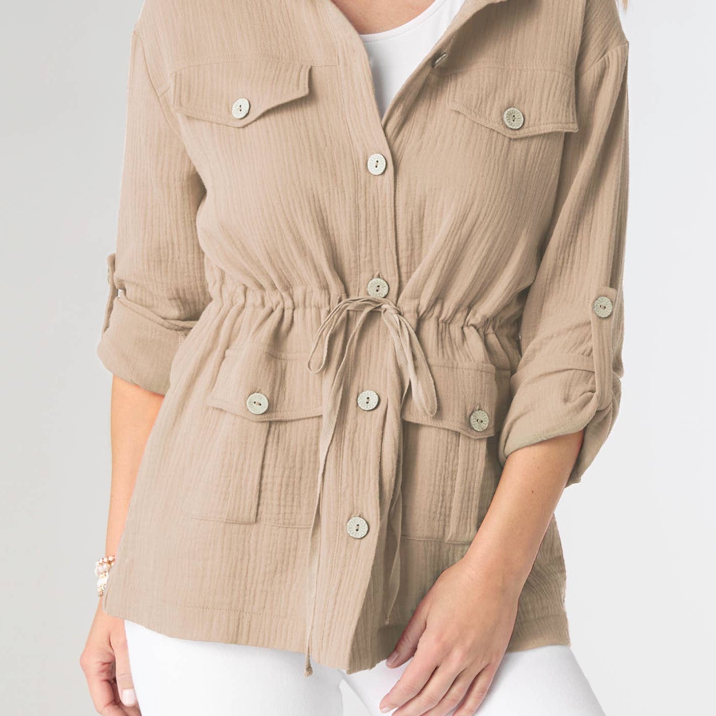 Woman wearing a beige jacket with a white background