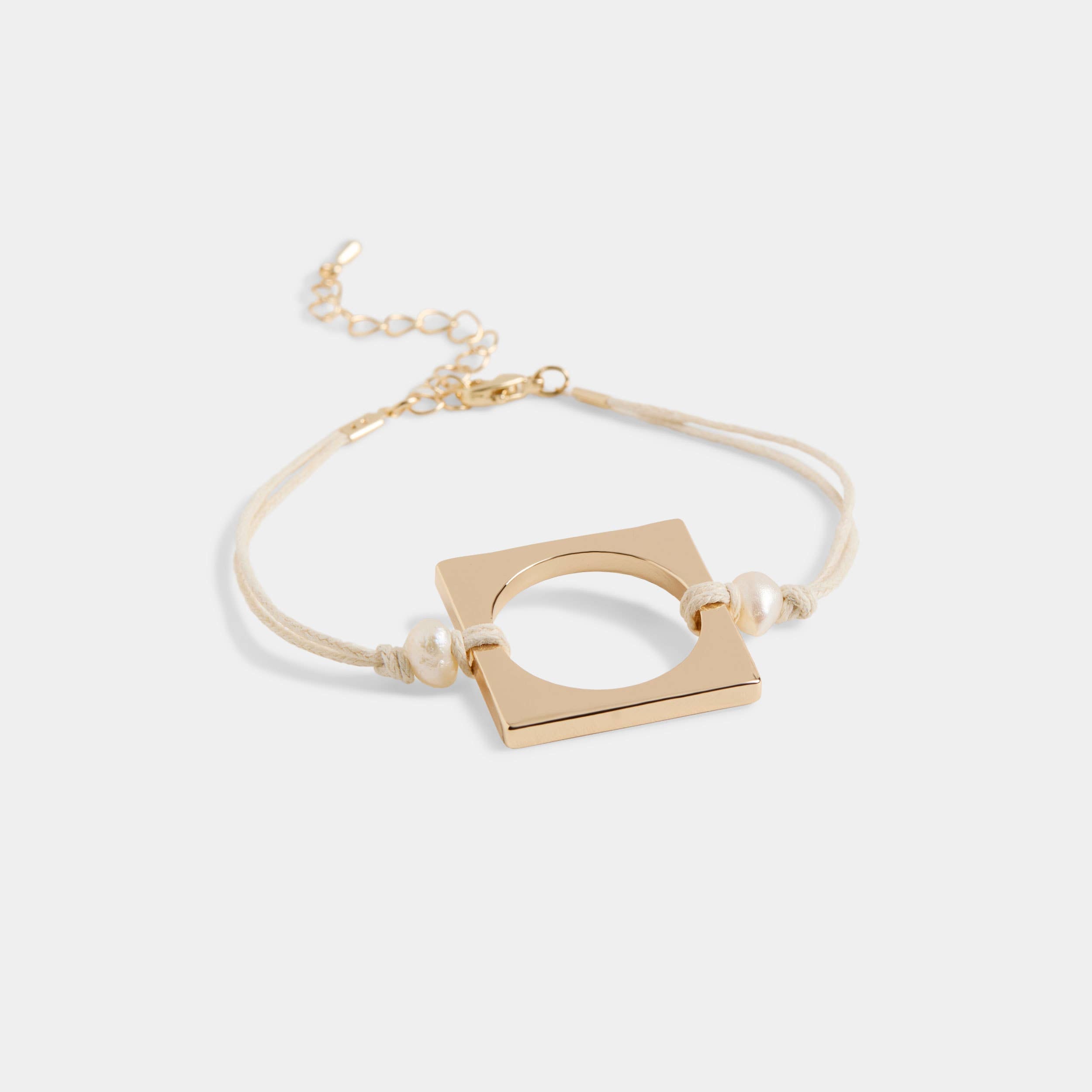 Delicate gold ring with small loop detail bracelet on white background