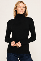 Black fitted turtleneck sweater styled with jeans for a classic fall layering look