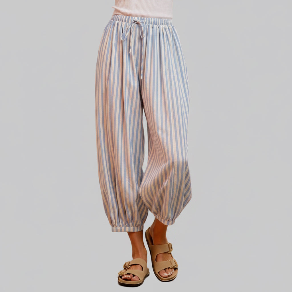 Striped pants worn by a person on a pink background