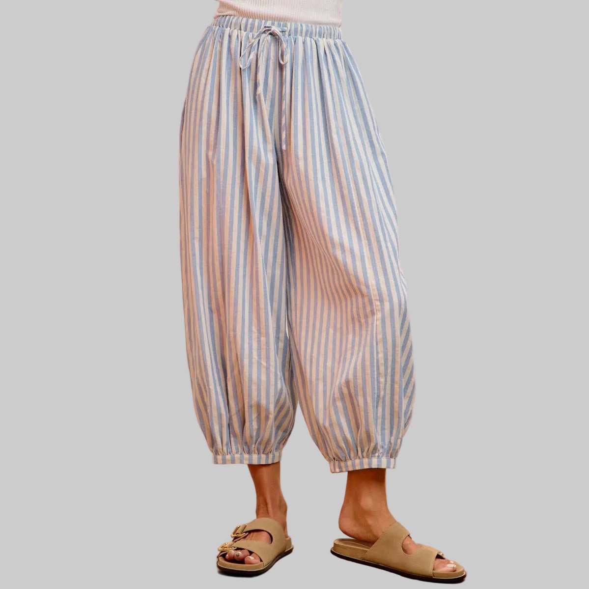 Striped pants worn by a person on a pink background