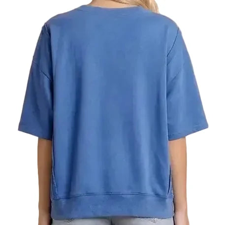 Person wearing a blue oversized t-shirt and denim shorts on a white background
