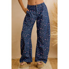 Woman wearing navy floral print relaxed wide leg pants, full front view