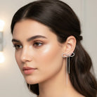 Woman wearing rhinestone drop earrings earring with dangling elements.