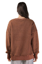 Back view of a women's chocolate brown oversized fleece top with drop shoulders and a longer back hem