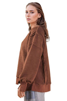 Side view of a chocolate brown oversized fleece pullover showing the relaxed fit, long sleeves and side slit hem