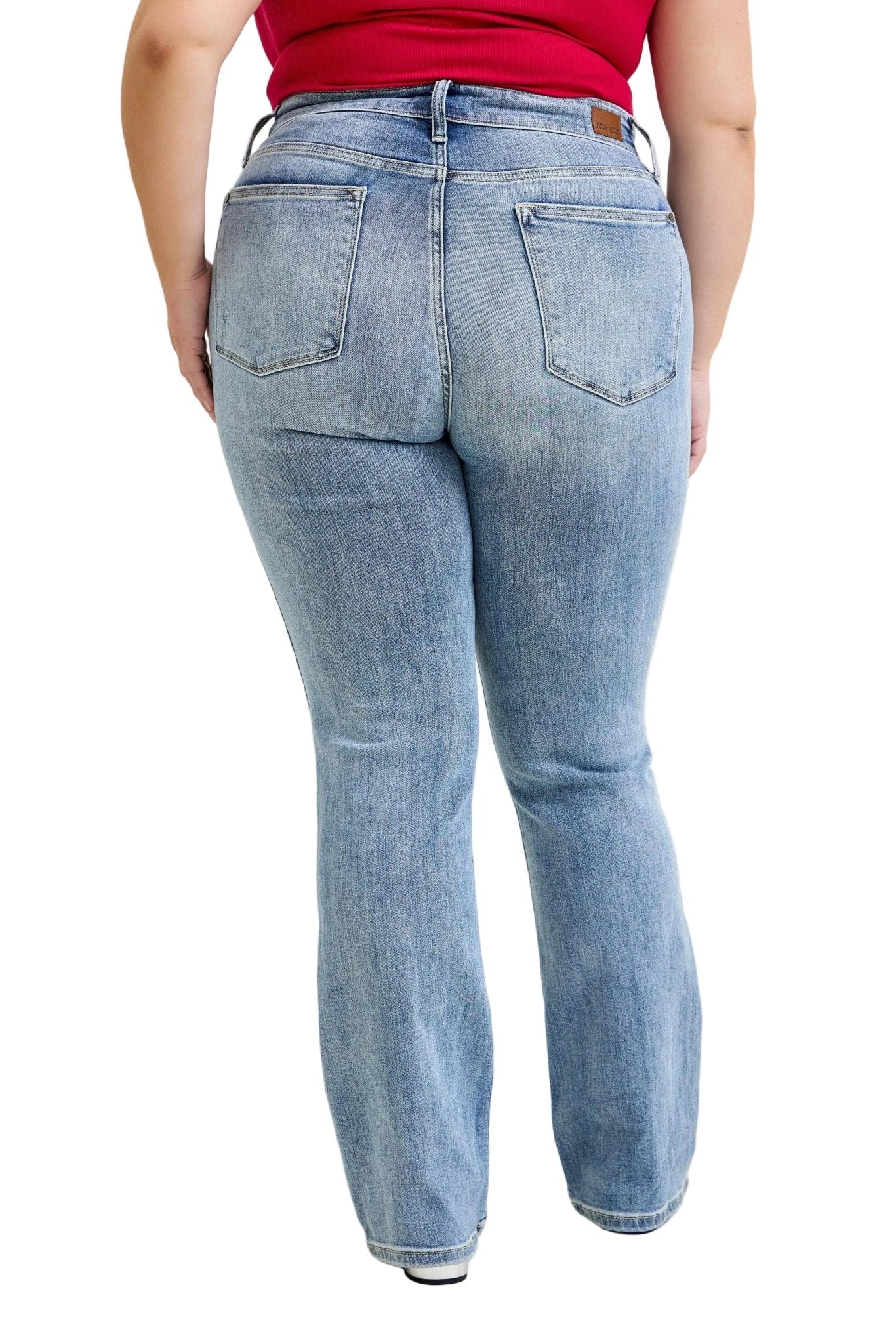 Person wearing light blue jeans on a plain background