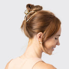 Woman with a high bun secured by a gold KITSCH open shape claw clip