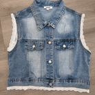 Denim vest with lace trim on a wooden surface