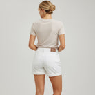woman in beige shirt and white shorts.  The picture is of the back of the shorts.  White background.