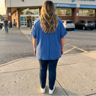 Person standing on a sidewalk in front of a Walgreens pharmacy.