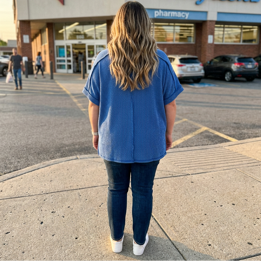 Person standing on a sidewalk in front of a Walgreens pharmacy.