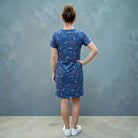 Person wearing a blue firework dress with a pattern against a gray wall