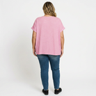 Person wearing a pink t-shirt and blue jeans on a white background