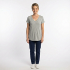 Woman wearing a gray t-shirt and blue pants on a white background