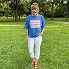 Woman wearing a blue t-shirt with an American flag design in a park