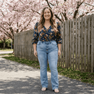 Woman standing outdoors with cherry blossom trees in the background