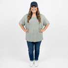 woman wearing baseball cap and ribbed long t-shirt with jeans