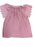 Pink blouse with eyelet sleeves on a white background